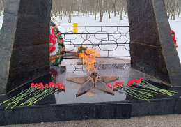 Жители Лобни несут цветы к мемориалу "Звонница" 