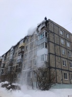 Городские коммунальные службы расчищают кровли домов от снега и наледи